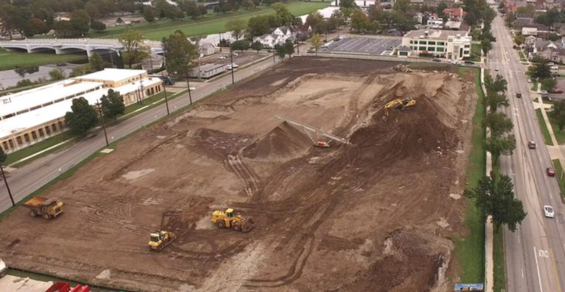 An empty dirt lot with construction vehicles on it.